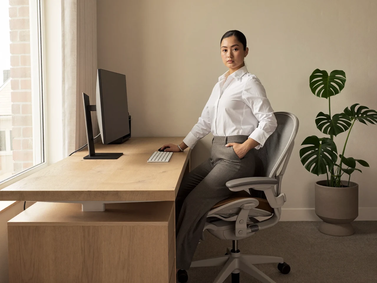 Helles Heimbüro mit Eichen-Sitz-Steh-Tisch, ergonomischem Stuhl und ausgeschaltetem Monitor