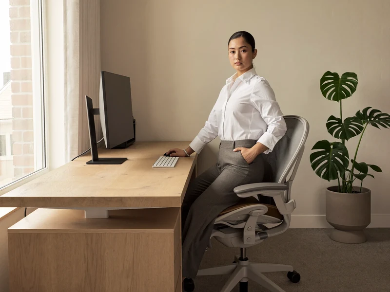 Helles Heimbüro mit Eichen-Sitz-Steh-Tisch, ergonomischem Stuhl und ausgeschaltetem Monitor